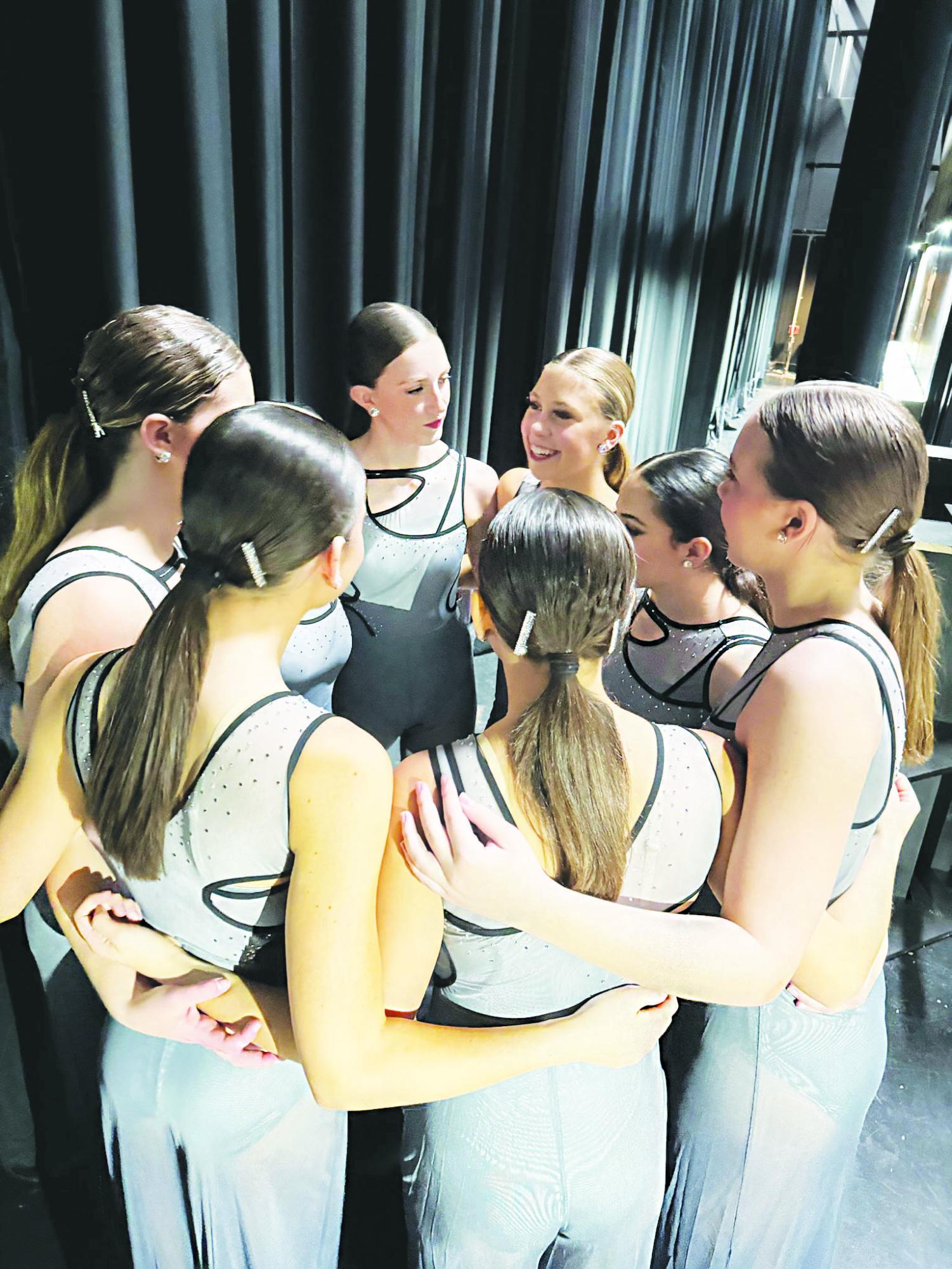 Ava Broll 25 huddles in a pep talk with her competition team prior to doing their contemporary dance Succession on stage. 