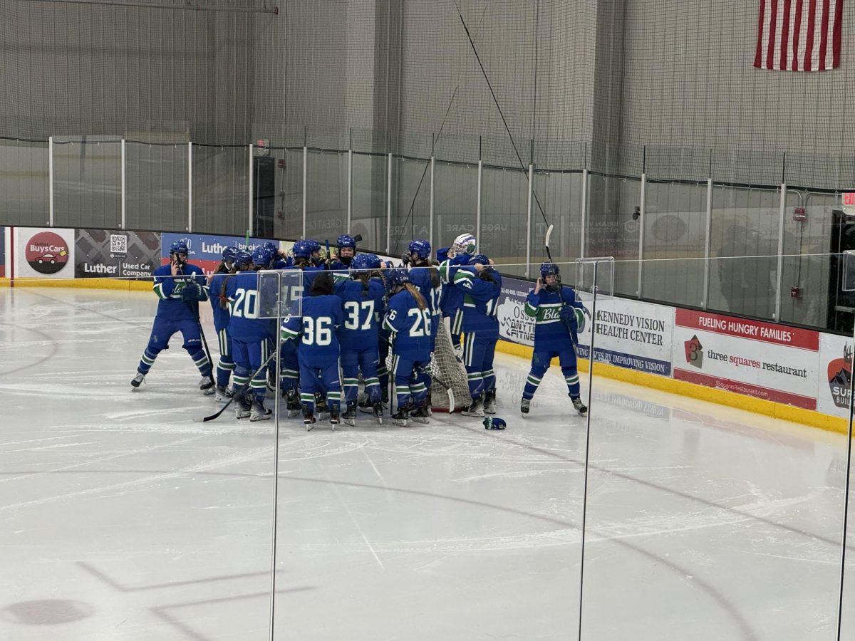 Members of the hockey team huddle on the ice during their five to zero win at the Osseo/Maple Grove Ice Rink on Nov. 9.